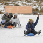 
              Visitors enjoy the snow at the Afriski ski resort near Butha-Buthe, Lesotho, Saturday July 30, 2022. While millions across Europe sweat through a summer of record-breaking heat, Afriski in the Maluti Mountains is Africa's only operating ski resort south of the equator. It draws people from neighboring South Africa and further afield by offering a unique experience to go skiing in southern Africa. (AP Photo/Jerome Delay)
            