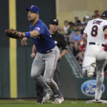 
              Minnesota Twins' Jake Cave reaches first base safely following a throwing error to Texas Rangers first baseman Nathaniel Lowe, left, in the fifth inning of a baseball game, Saturday, Aug. 20, 2022, in Minneapolis. (AP Photo/Jim Mone)
            