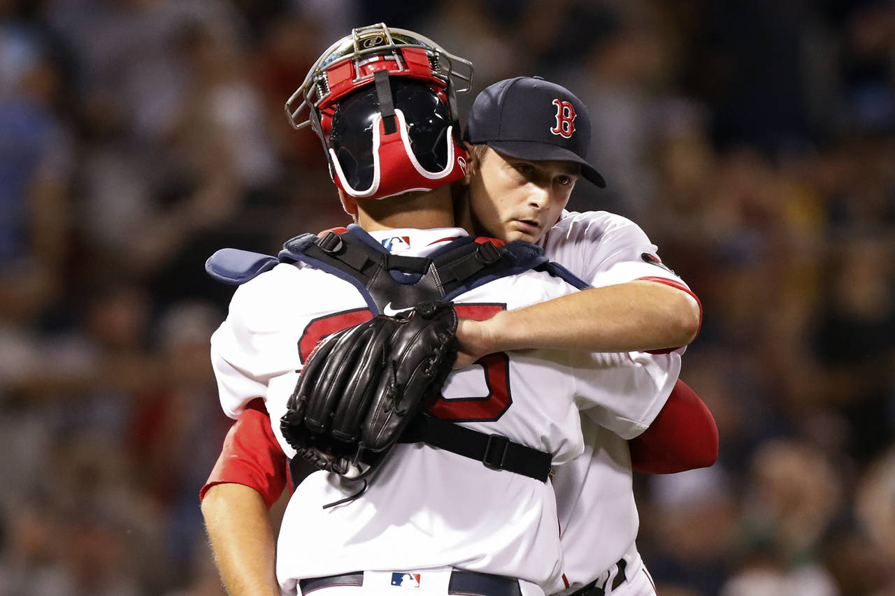 Boston Red Sox closer Garrett Whitlock, right, is congratulated by catcher Kevin Plawecki, left, af...
