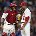 
              St. Louis Cardinals catcher Yadier Molina, left, talks to starting pitcher Jose Quintana (63) during the sixth inning in the second game of a baseball doubleheader against the Chicago Cubs Thursday, Aug. 4, 2022, in St. Louis. (AP Photo/Jeff Roberson)
            