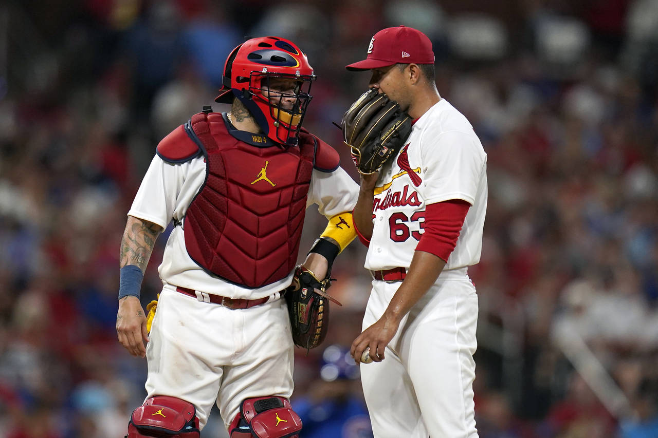 St. Louis Cardinals catcher Yadier Molina, left, talks to starting pitcher Jose Quintana (63) durin...