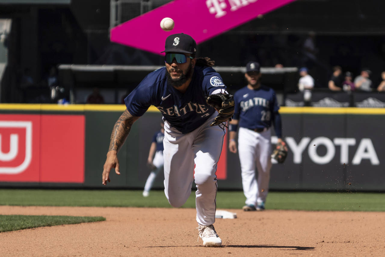 Seattle Mariners shortstop J.P. Crawford tosses a ground ball hit by Cleveland Guardians' Josh Nayl...