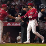 
              Los Angeles Angels' Shohei Ohtani, second from right, is congratulated by Mike Trout, left, as he scores after hitting a two-run home run as New York Yankees catcher Jose Trevino, right, stands at the plate during the fifth inning of a baseball game Monday, Aug. 29, 2022, in Anaheim, Calif. (AP Photo/Mark J. Terrill)
            