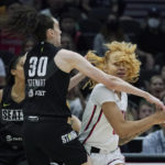 
              Washington Mystics center Shakira Austin, right, tries to pass the ball around the defense of Seattle Storm forward Breanna Stewart (30) during the first half of a WNBA basketball playoff game, Sunday, Aug. 21, 2022, in Seattle. (AP Photo/Ted S. Warren)
            