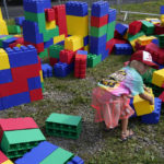 
              Paige Gianatasio, 5, plays with oversized blocks before a NASCAR Cup Series auto race in Watkins Glen, N.Y., Sunday, Aug. 21, 2022. (AP Photo/Seth Wenig)
            