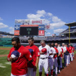 
              Washington Nationals manager Dave Martinez, left, and others observe a moment of silence for Los Angeles Dodgers broadcaster Vin Scully before a baseball game against the New York Mets at Nationals Park, Wednesday, Aug. 3, 2022, in Washington.  The Hall of Fame broadcaster, whose dulcet tones provided the soundtrack of summer while entertaining and informing Dodgers fans in Brooklyn and Los Angeles for 67 years, died Tuesday night. He was 94. (AP Photo/Alex Brandon)
            
