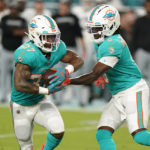 
              Miami Dolphins quarterback Teddy Bridgewater (5) hands the ball to running back Myles Gaskin (37) during the first half of a NFL preseason football game against the Las Vegas Raiders, Saturday, August 20, 2022, in Miami Gardens, Fla. (AP Photo/Wilfredo Lee)
            