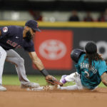 
              Cleveland Guardians Amed Rosario tags Seattle Mariners' J.P. Crawford out at second on a steal attempt during the third inning of a baseball game, Friday, Aug. 26, 2022, in Seattle. (AP Photo/John Froschauer)
            