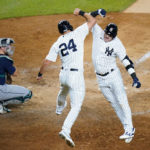 
              Seattle Mariners catcher Cal Raleigh watches as New York Yankees' Matt Carpenter, center, celebrates with teammate Josh Donaldson after Donaldson hit a two-run home run during the sixth inning of a baseball game Tuesday, Aug. 2, 2022, in New York. (AP Photo/Frank Franklin II)
            