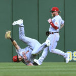 
              Cincinnati Reds center fielder Albert Almora (3) tumbles after making the catch on a ball hit by Pittsburgh Pirates' Bligh Madris, as right fielder Jake Fraley watches during the third inning of a baseball game, Friday, Aug. 19, 2022, in Pittsburgh. (AP Photo/Philip G. Pavely)
            