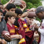 
              Washington Commanders wide receiver Terry McLaurin, right, signs autographs for fans after practice during NFL football training camp Monday, Aug. 15, 2022, in Ashburn, Va. (AP Photo/Alex Brandon)
            