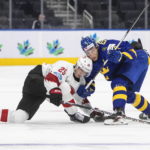 
              Sweden's Simon Edvinsson (7) and Switzerland's Jonas Taibel (25) battle for the puck during the third period of an IIHF world junior hockey championships game in Edmonton, Alberta on Wednesday, Aug. 10, 2022. (Jason Franson/The Canadian Press via AP)
            
