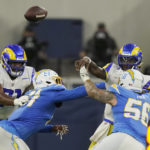 
              Los Angeles Rams quarterback Bryce Perkins, top right, throws under pressure from Los Angeles Chargers' Morgan Fox (56) during the first half of a preseason NFL football game Saturday, Aug. 13, 2022, in Inglewood, Calif. (AP Photo/Mark J. Terrill)
            