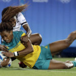 
              FILE - Australia's Ellia Green, front, scores a try as Fiji's Raijieli Daveua, tries to defend during the women's rugby sevens match between Australia and Fiji at the Summer Olympics in Rio de Janeiro, Brazil, Saturday, Aug. 6, 2016.  Green, one of the stars of Australia's gold medal-winning women's rugby sevens team at the 2016 Olympics, has transitioned to male. The 29-year-old, Fiji-born Green is going public in a video at an international summit aimed at ending transphobia and homophobia in sport. The summit is being hosted in Ottawa as part of the Bingham Cup rugby tournament. (AP Photo/Themba Hadebe, File)
            