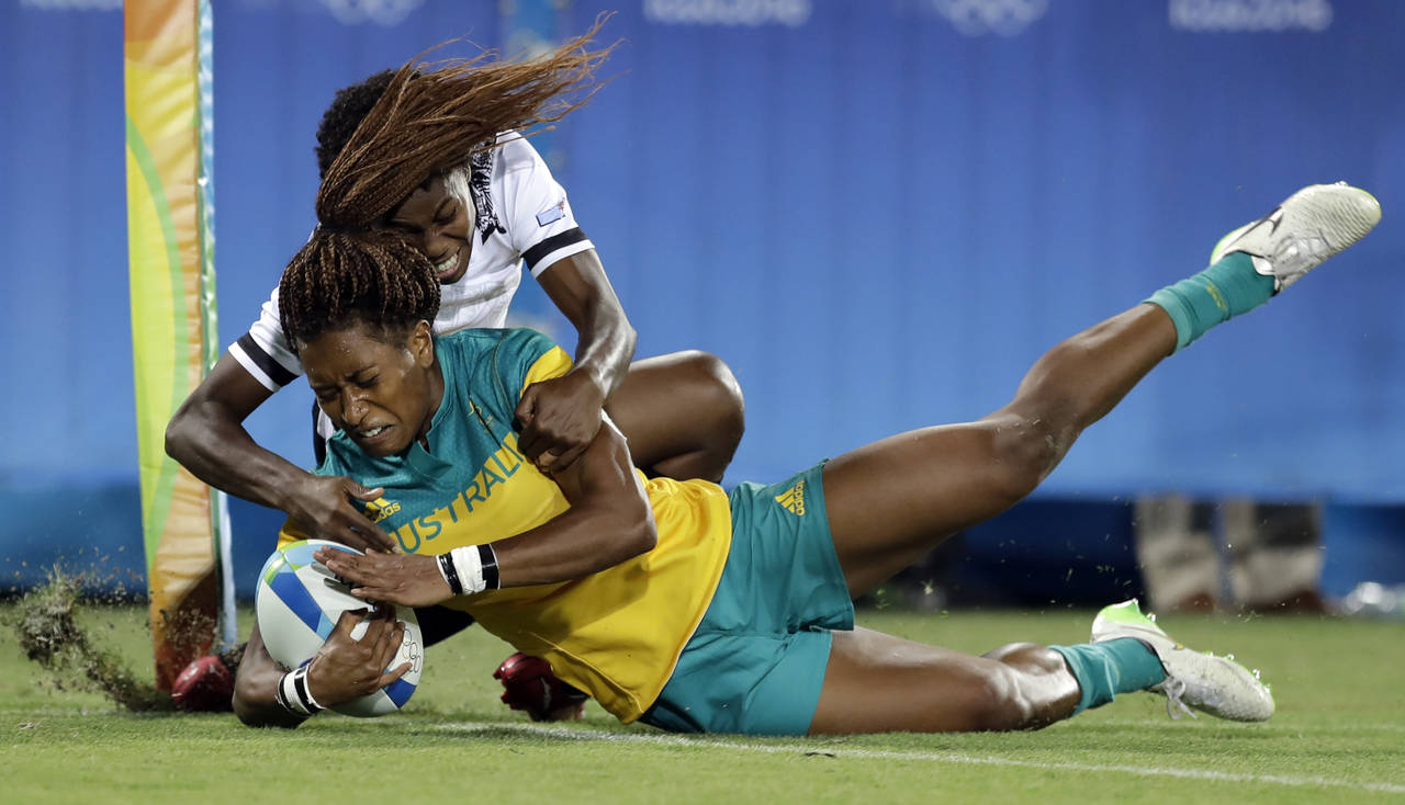 FILE - Australia's Ellia Green, front, scores a try as Fiji's Raijieli Daveua, tries to defend duri...