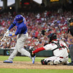 
              Chicago Cubs' Ian Happ, left, hits an RBI-single during the fifth inning of a baseball game against the Cincinnati Reds, Saturday, Aug. 13, 2022, in Cincinnati. (AP Photo/Jeff Dean)
            