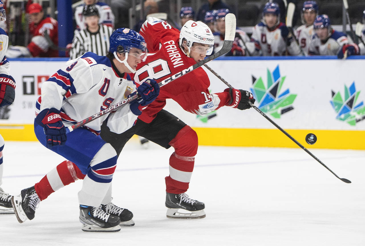 United States' Sean Behrens (3) and Switzerland's Joshua Fahrni (18) vie for the puck during the fi...