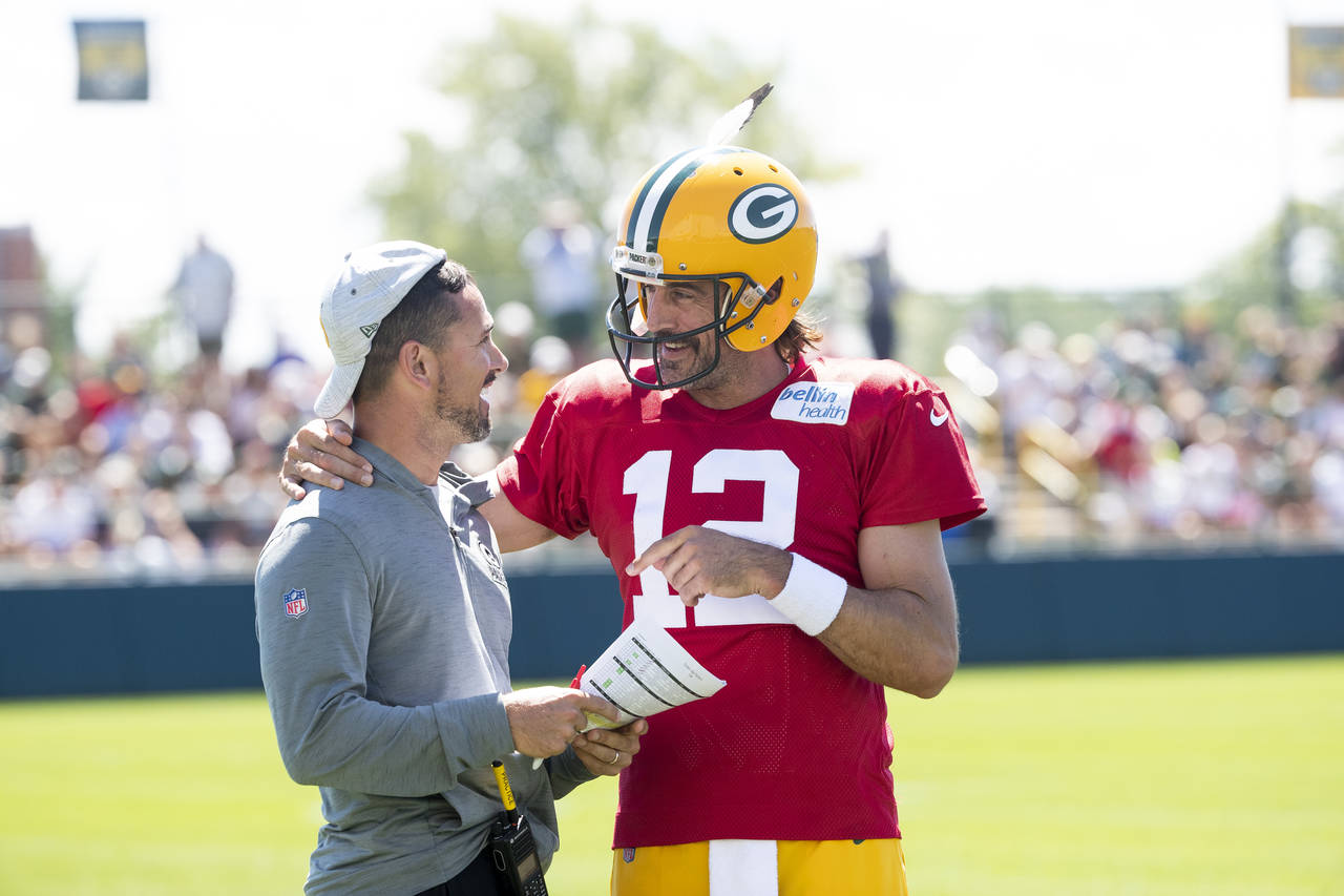 Green Bay Packers quarterback Aaron Rodgers (12) flips head coach Matt LaFleur's hat backwards duri...