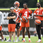 
              Cleveland Browns quarterbacks Deshaun Watson (4) and Jacoby Brissett (7) laugh during the NFL football team's training camp, Monday, Aug. 1, 2022, in Berea, Ohio. (AP Photo/Nick Cammett)
            