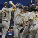 
              San Diego Padres' Jake Cronenworth (9) is congratulated by his teammates after hitting a grand slam in the first inning of a baseball game against the Miami Marlins, Wednesday, Aug. 17, 2022, in Miami. (AP Photo/Marta Lavandier)
            