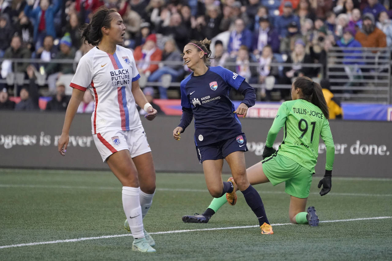 FILE - San Diego Wave forward Alex Morgan, center, reacts after she scored a goal against OL Reign ...