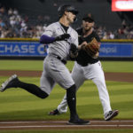 
              Arizona Diamondbacks pitcher Merrill Kelly, right, tags out Colorado Rockies' Randal Grichuk, left, in the fourth inning during a baseball game, Saturday, Aug. 6, 2022, in Phoenix. (AP Photo/Rick Scuteri)
            
