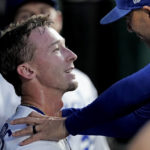 
              Kansas City Royals' Drew Waters, left, is congratulated by Alec Zumwalt, right, in the dugout after getting his first major league hit during the third inning of a baseball game against the Arizona Diamondbacks Wednesday, Aug. 24, 2022, in Kansas City, Mo. (AP Photo/Charlie Riedel)
            