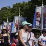 
              A banner of Serena Williams hangs over tennis fans as they walk through the grounds of the Billie Jean King National Tennis Center during the first round of the US Open tennis championships, Monday, Aug. 29, 2022, in New York. (AP Photo/Charles Krupa)
            