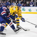 
              USA's Landon Slaggert (19) and Sweden's Simon Edvinsson (7) battle for the puck during second period IIHF World Junior Hockey Championship action in Edmonton, Alberta, on Sunday Aug. 14, 2022. (Jason Franson/The Canadian Press via AP)
            