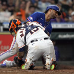
              Texas Rangers' Ezequiel Duran, rear, is tagged out at home plate by Houston Astros catcher Martin Maldonado (15) during the seventh inning of a baseball game Wednesday, Aug. 10, 2022, in Houston. (AP Photo/David J. Phillip)
            