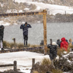 
              Visitors have their picture taken as snow falls at the Afriski ski resort near Butha-Buthe, Lesotho, Saturday July 30, 2022. While millions across Europe sweat through a summer of record-breaking heat, Afriski in the Maluti Mountains is Africa's only operating ski resort south of the equator. It draws people from neighboring South Africa and further afield by offering a unique experience to go skiing in southern Africa. (AP Photo/Jerome Delay)
            