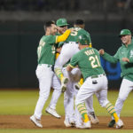 
              Oakland Athletics' Chad Pinder (obscured) is congratulated by teammates after grounding into a force out and reaching first safely on a throwing error by New York Yankees second baseman DJ LeMahieu, driving in the winning run in the 11th inning of a baseball game in Oakland, Calif., Saturday, Aug. 27, 2022. (AP Photo/Godofredo A. Vásquez)
            