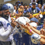 
              Dallas Cowboys running back Ezekiel Elliott, left, gives autographs to fans at the end of practice at NFL football training camp, Monday, Aug. 1, 2022, in Oxnard, Calif. (AP Photo/Gus Ruelas)
            