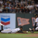 
              Pittsburgh Pirates third baseman Rodolfo Castro, left, dives in vain for a ground ball in the hole by San Francisco Giants' Wilmer Flores during the fifth inning of a baseball game, Friday, Aug. 12, 2022, in San Francisco. Shortstop Oneil Cruz (15) fielded the ball and threw out Flores at first base. (AP Photo/D. Ross Cameron)
            