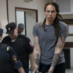 
              WNBA star and two-time Olympic gold medalist Brittney Griner is escorted from a court room ater a hearing, in Khimki just outside Moscow, Russia, Thursday, Aug. 4, 2022. A judge in Russia has convicted American basketball star Brittney Griner of drug possession and smuggling and sentenced her to nine years in prison. (AP Photo/Alexander Zemlianichenko)
            