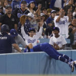 
              Los Angeles Dodgers left fielder Chris Taylor (3) falls in to the stands while catching a foul ball hit by Milwaukee Brewers' Omar Narvaez during the fifth inning of a baseball game in Los Angeles, Monday, Aug. 22, 2022. (AP Photo/Ashley Landis)
            