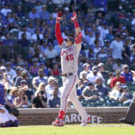 
              Washington Nationals' Joey Meneses celebrates his homer off Chicago Cubs starting pitcher Justin Steele as catcher Yan Gomes and home plate umpire Mike Muchlinski watch during the sixth inning of a baseball game Wednesday, Aug. 10, 2022, in Chicago. (AP Photo/Charles Rex Arbogast)
            