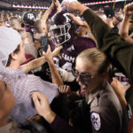
              FILE - Texas A&M students celebrate with Texas A&M defensive lineman Isaiah Raikes (34) as they packed Kyle Field after upsetting Alabama 38-41 in an NCAA college football game on Oct. 9, 2021, in College Station, Texas. The “Beef Bowl,” which draws from comments Aggies coach Jimbo Fisher and Crimson Tide coach Nick Saban made about each other over concerns about NIL after Fisher brought in one of the top recruiting classes in history. (AP Photo/Sam Craft, File)
            