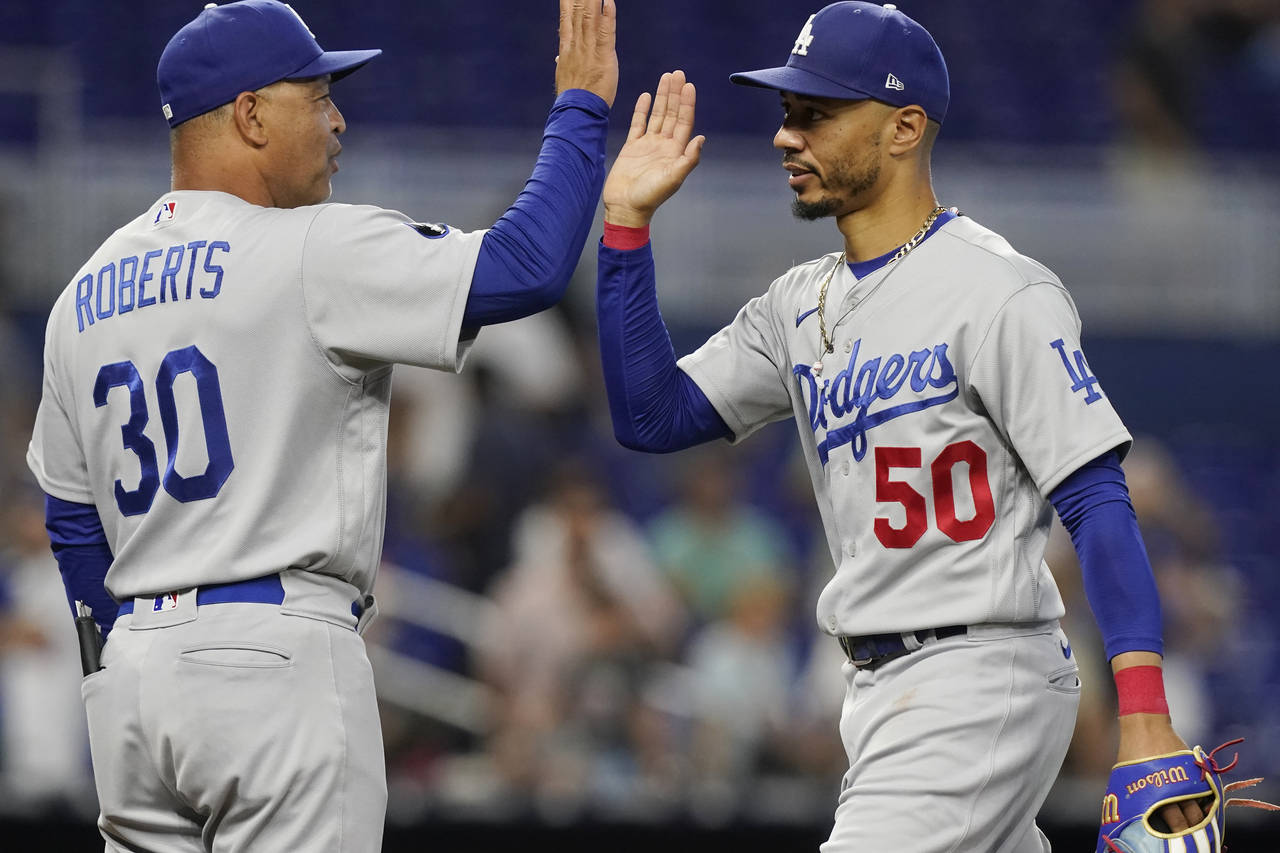 L.A. Dodgers manager Dave Roberts (30) congratulates right fielder Mookie Betts (50) at the end of ...