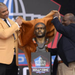 
              Former NFL player Richard Seymour, left, and his high school principal Titus Durea unveil his bust before speaking during his induction into the Pro Football Hall of Fame, Saturday, Aug. 6, 2022, in Canton, Ohio. (AP Photo/David Richard)
            