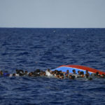 
              Migrants swim next to their overturned wooden boat during a rescue operation by Spanish NGO Open Arms at south of the Italian Lampedusa island at the Mediterranean sea, Thursday, Aug. 11, 2022. Forty migrants from Eritrea and Sudan, two children and one woman, were rescued by NGO Open Arms crew members and Italian coast guard after their boat overturned and started to sink. (AP Photo/Francisco Seco)
            