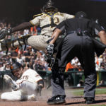 
              Umpire Adrian Johnson, right, watches as San Francisco Giants' Luis Gonzalez, bottom, slides home to score under San Diego Padres catcher Luis Campusano during the sixth inning of a baseball game in San Francisco, Wednesday, Aug. 31, 2022. (AP Photo/Jeff Chiu)
            