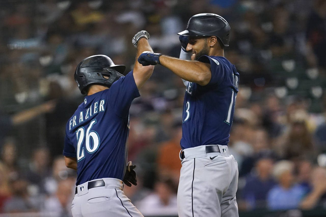 Seattle Mariners' Abraham Toro, right, celebrates his two-run home run with Adam Frazier (26) in th...