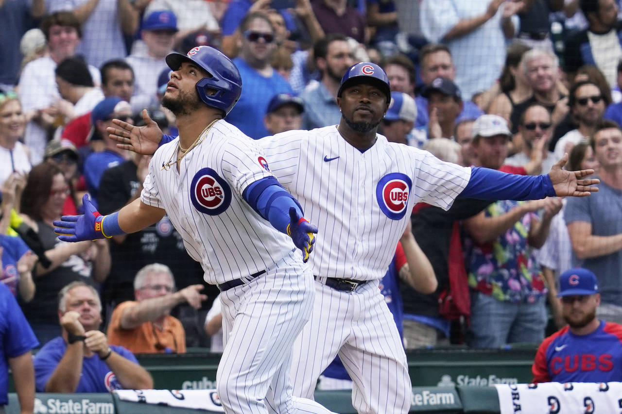 Chicago Cubs' Willson Contreras, left, and third base coach Willie Harris react after Contreras hit...