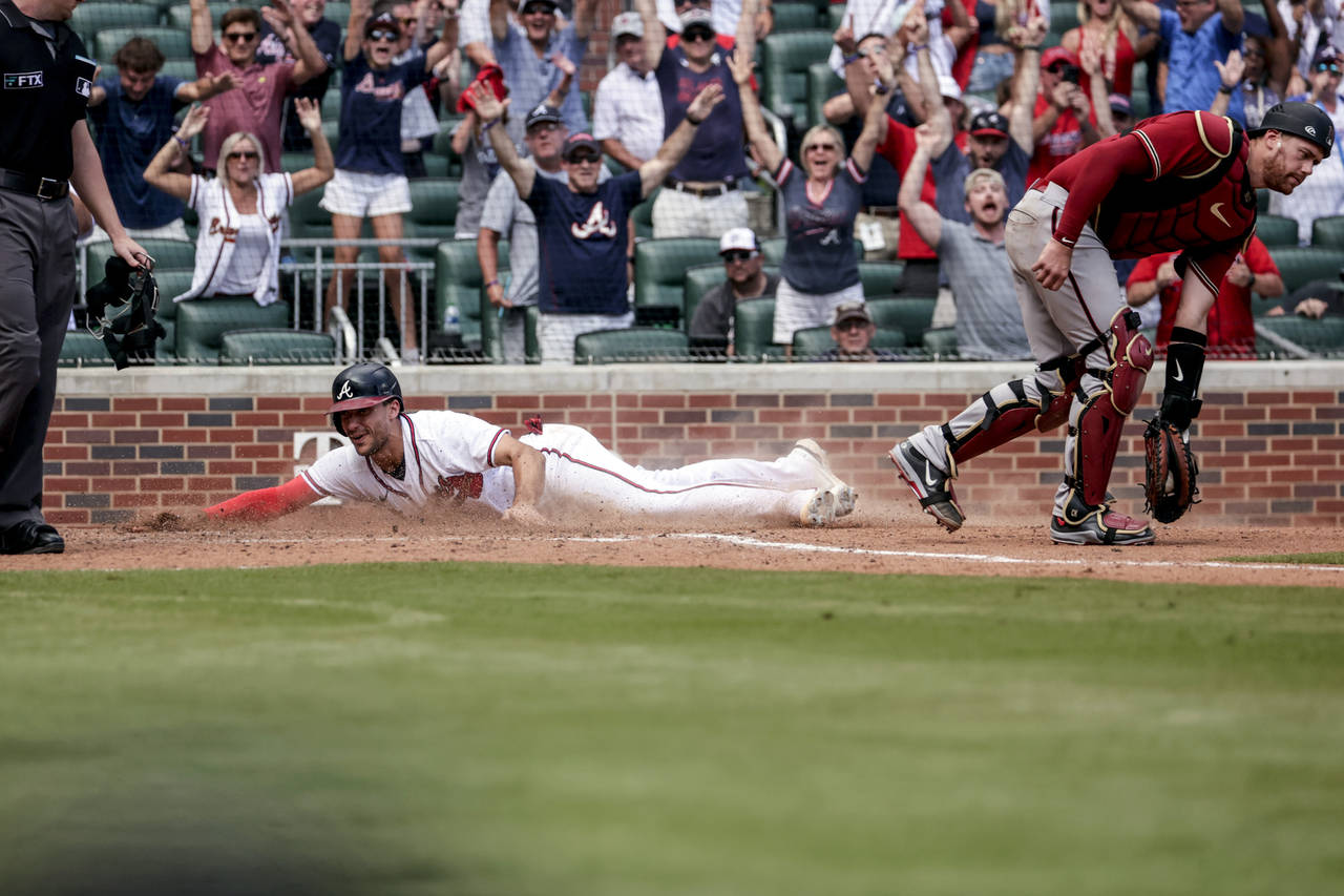 Atlanta Braves' Matt Olson slides safely into home on a game winning RBI from Austin Riley during t...