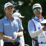 
              Will Zalatoris, left, talks with his caddie after hitting on the 18th tee during the third round of the St. Jude Championship golf tournament, Saturday, Aug. 13, 2022, in Memphis, Tenn. (AP Photo/Mark Humphrey
            