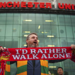 
              A man sells scarves outside the Old Trafford ground, Manchester, England, Monday Aug. 22, 2022, ahead of an organised protest against the Manchester United owners before the Premier League match between Manchester United and Liverpool. (Peter Byrne/PA via AP)
            