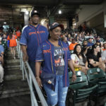 
              The parents of Houston Astros' Yordan Alvarez, Agustín Eduardo Álvarez Salazar, rear, and Mailyn Cadogan Reyes walk to their seats to watch the Minnesota Twins and Houston Astros play a baseball game Tuesday, Aug. 23, 2022, in Houston. Alvarez's parents got to see him play as a professional for the first time Tuesday night after arriving from Cuba Friday. (AP Photo/David J. Phillip)
            