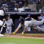 
              Tampa Bay Rays' Jose Siri scores a run past New York Yankees catcher Jose Trevino during the ninth inning of a baseball game  Monday, Aug. 15, 2022, in New York. (AP Photo/Adam Hunger)
            