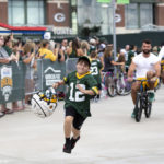 
              FILE - Green Bay Packers tight end Josiah Deguara, third from right, rides a young fan's bike as the fan takes off running with Deguara's helmet during the team's NFL football training camp July 27, 2022, in Green Bay, Wisc. (Samantha Madar/The Post-Crescent via AP, File)
            